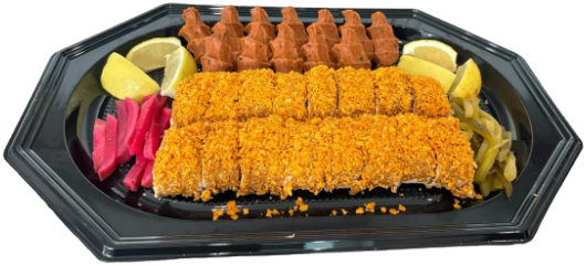 Servierplatte mit Çiğköfte, Zitronenspalten, eingelegtem Gemüse und frischem Salat.